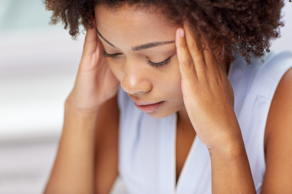 Young woman with her hands on the side of her face, stressed