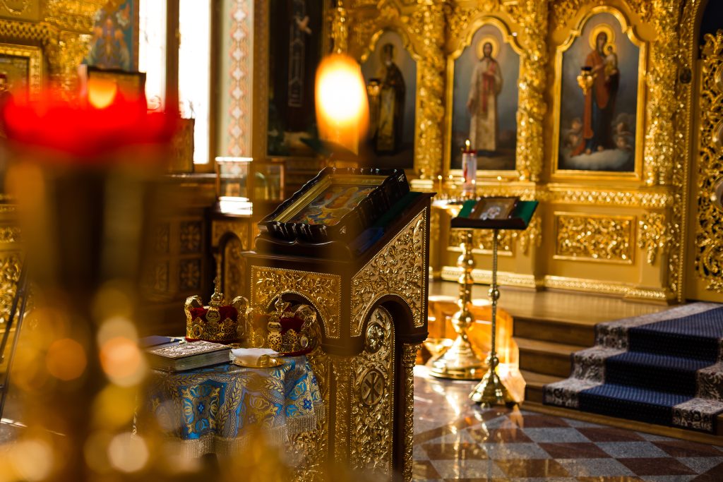 The inside of an Orthodox Christian church with icons and lit candles